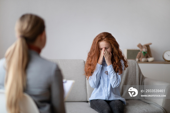 Child Psychologist. Worried sad teen girl crying during consultation