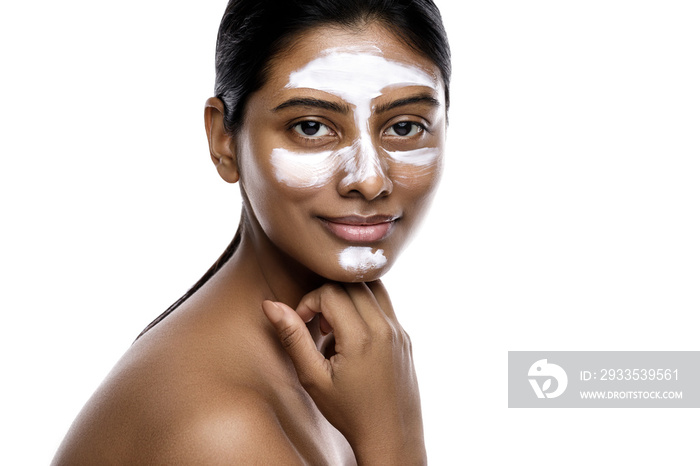 Young indian woman with a cleansing mask applied on her face