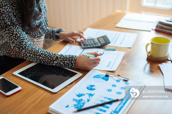 Female businessmen are calculating taxes from the profits of the company. Creditors are calculating and writing invoices to their debtors. Women are calculating about her expenses and liabilities.