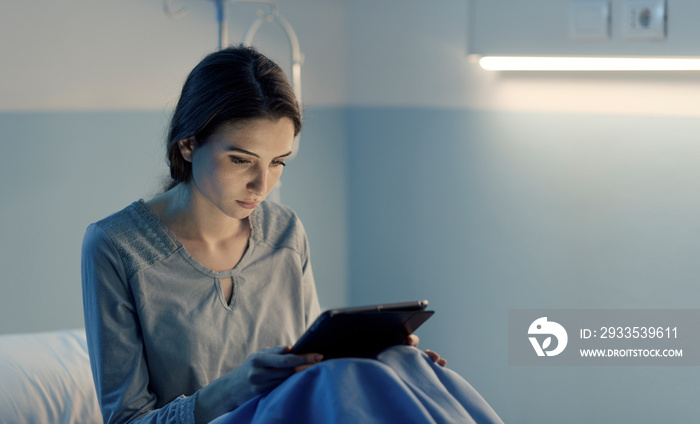 Young sleepless patient at the hospital connecting with a tablet