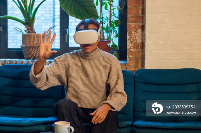 Woman sitting on sofa and using virtual reality headset