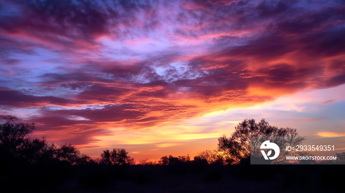 Beautiful sunset sky filled with warm shades of orange, pink, and purple, the soft, wispy clouds, background, wallpaper.