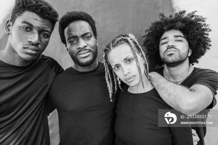 Portrait of group of young african people looking at camera outdoor - Focus on girl face - Black and white editing