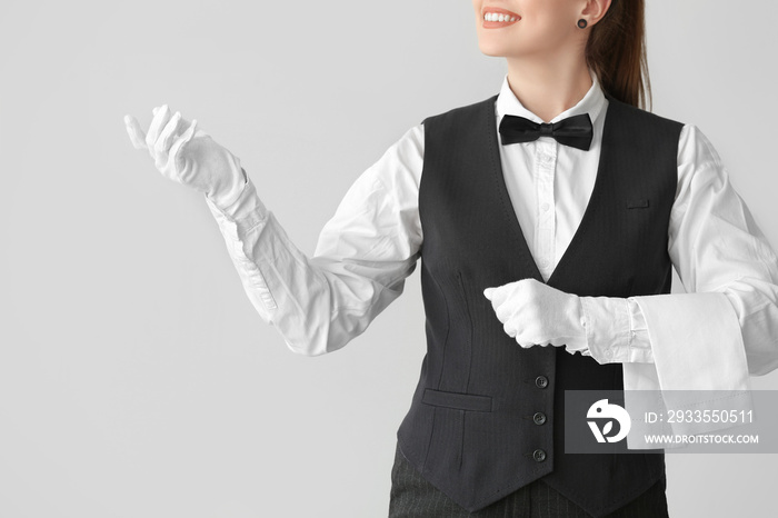 Beautiful female waiter on grey background