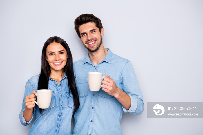 Photo of two amazing colleagues working together spend coffee break holding hot drink cups wear casual jeans clothes isolated grey color background