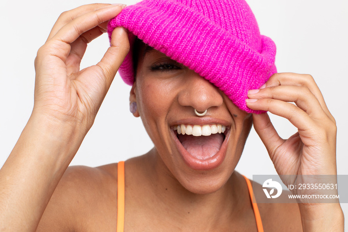 Studio portrait of smiling woman in pink woolen cap