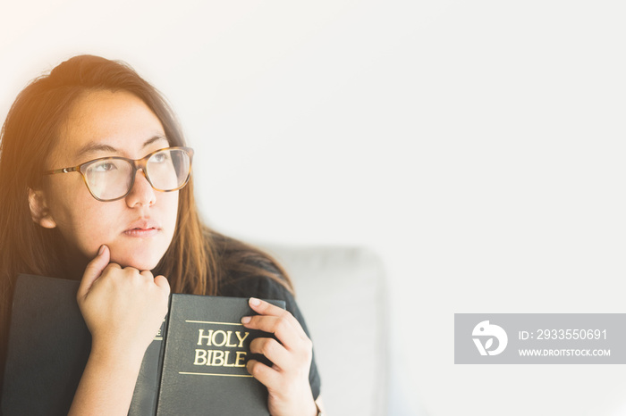 Christian asian woman read holy bible and thinking isolated on white background