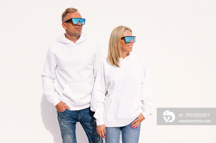 Woman and man wearing white hoodies, mockup for custom hoody sweatshirt design