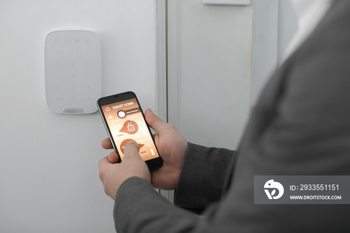 Man with mobile phone using smart home security system application