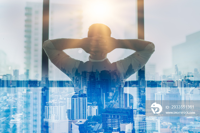 Portrait of relaxed businessman in modern office.Business young man relax after work of office window with business district view.