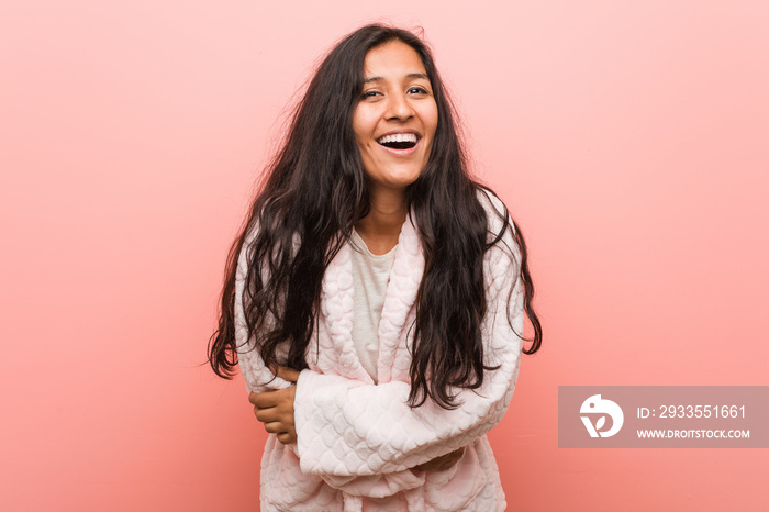 Young indian woman wearing pajama laughing and having fun.