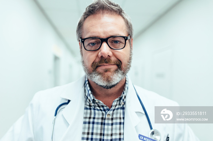 Mature male medical doctor standing in hospital