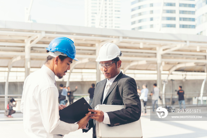 Civil engineer teams meeting working together wear worker helmets hardhat on construction site in modern city. Foreman industry project manager engineer teamwork. Asian industry professional team