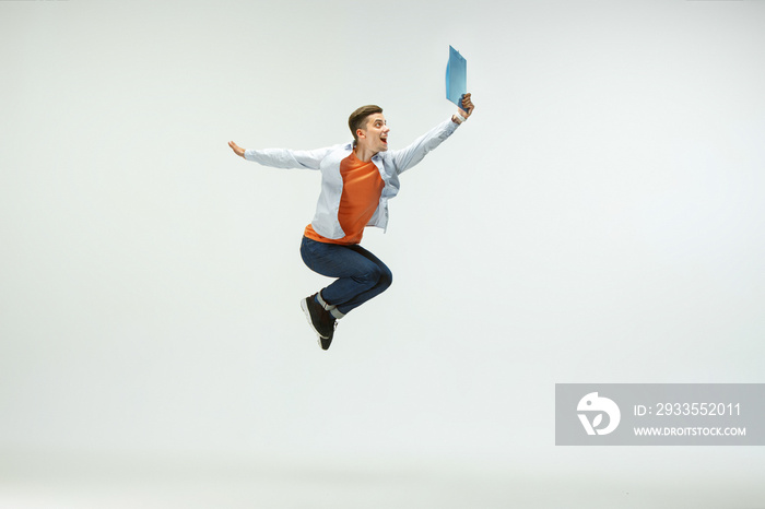 Happy young man working at office, jumping and dancing in casual clothes or suit isolated on white studio background. Business, start-up, working open-space, ballet or professional occupation concept.