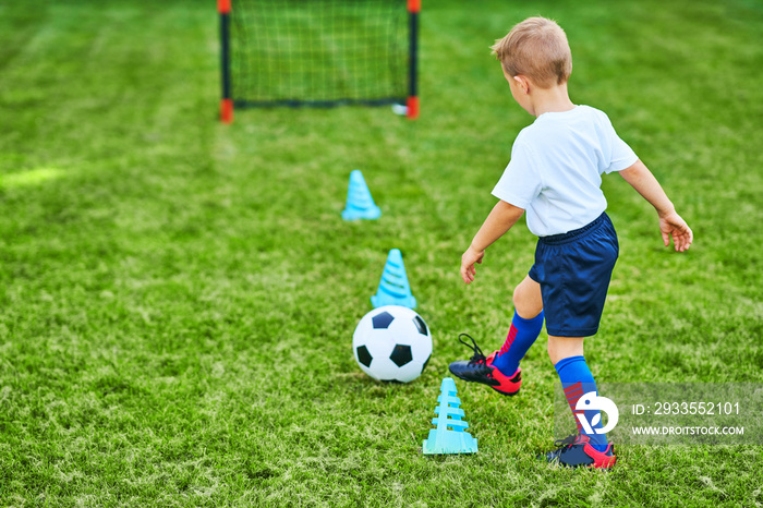 Little Boy practising soccer outdoors