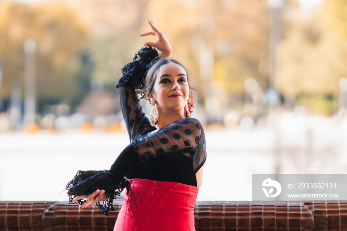 Woman dancing flamenco while raise the hands and wear a traditional dress