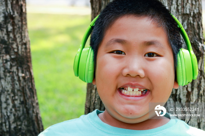 Fat Asian boy wears green music headphones