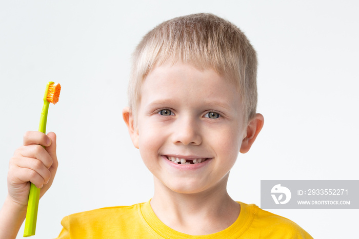 A cute caucasian little child is brushing his teeth with a toothbrush.