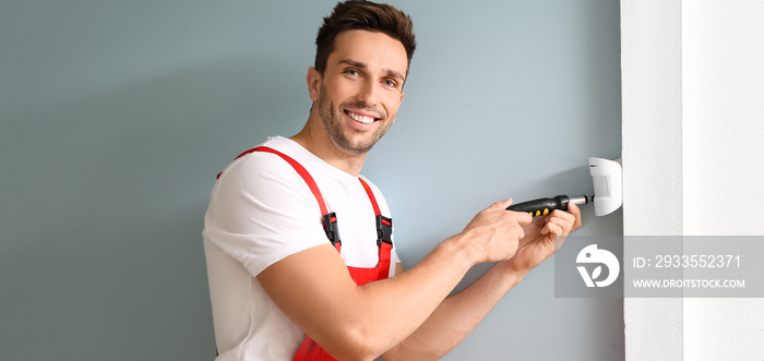 Technician installing smart home security system in room