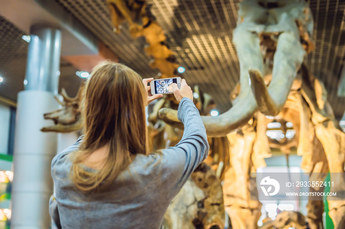 woman use mobile phone and blurred image of people in the dinosaur exhibition