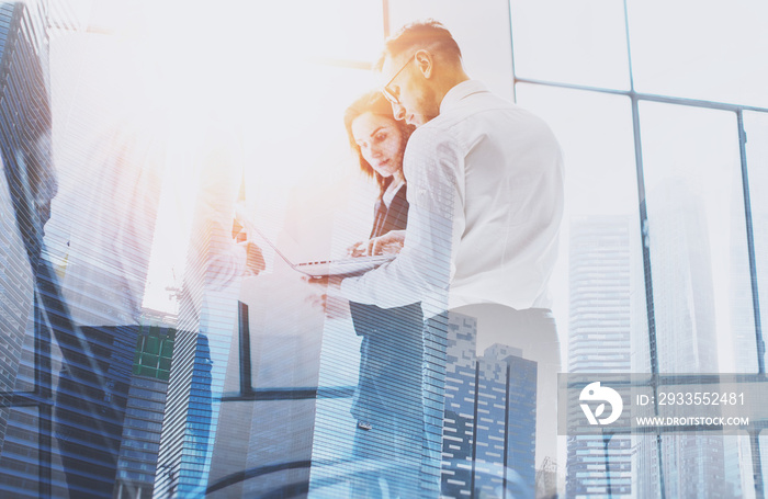 Group of businessmans on business meeting.Business team in working process.Double exposure,skyscraper building blurred background.Flares effect.