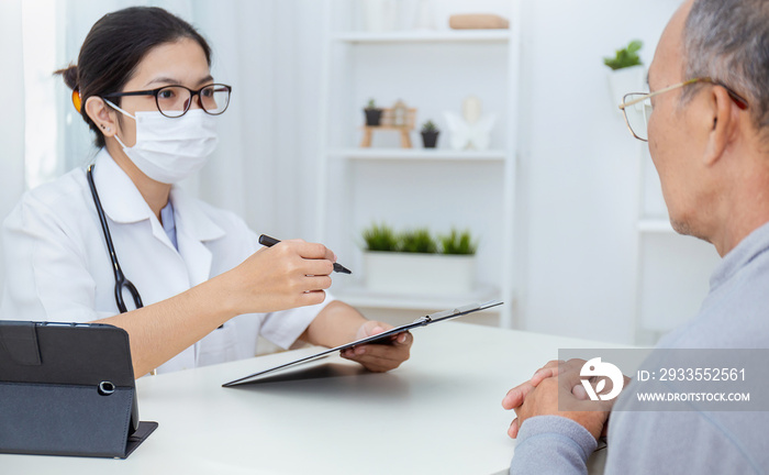 Portrait of asian woman doctor wear protection face mask show patient a clip board, patient listen to specialist doctor in clinic office. epidemic flu Coronavirus. Medical staff preventive.