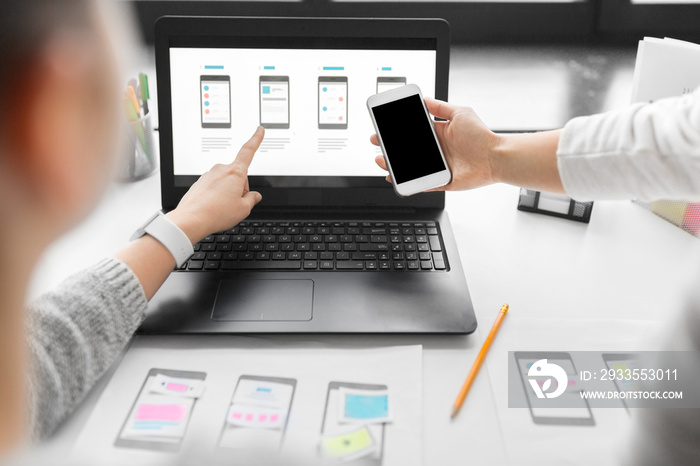 app design, technology and business concept - web designers or developers with laptop computer and smartphone working on user interface layout at office