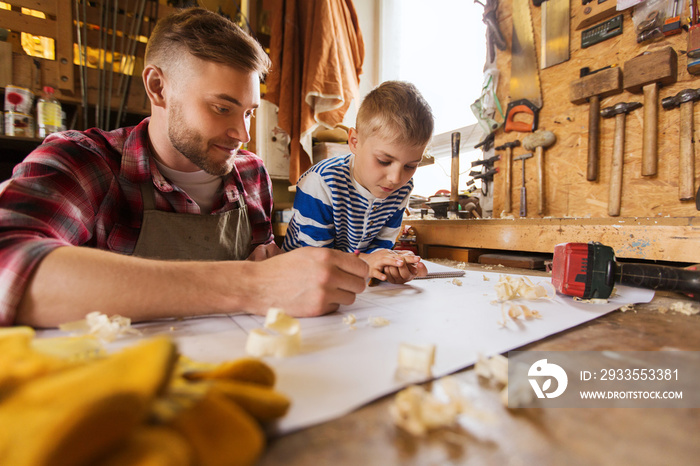 happy father and son with blueprint at workshop