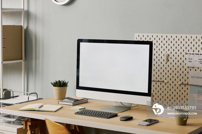 Blank computer screen on minimal home office workplace set at angle