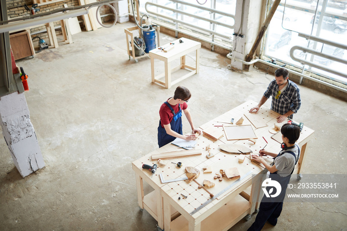Above view background of carpenters working with wood standing at table in workshop, copy space