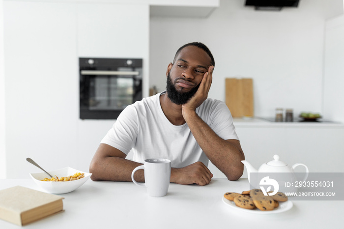 Black man suffering from insomnia sitting at desk