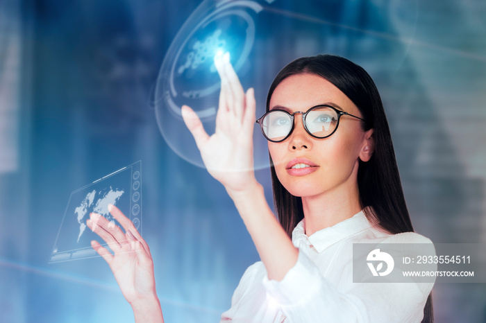 Innovative use of technology in business concept. A young business woman is operating inside an augmented reality, holographic space, monitoring data and analytics with a virtual 3D monitor