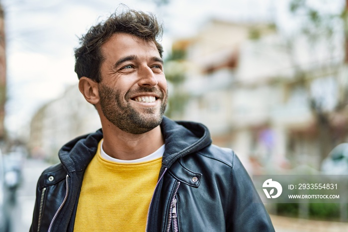 Handsome hispanic man with beard smiling happy outdoors