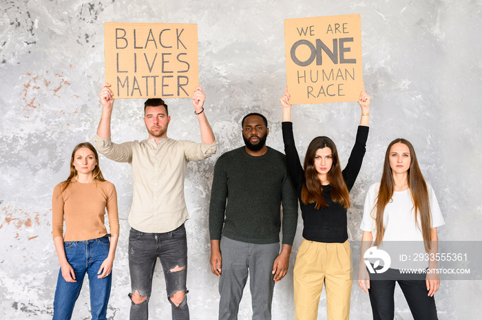 A protest against cruelty and racism. Multi-racial group of young people with signs  black lives matter ,  we are one human race  in studio