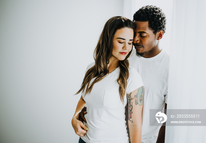 Happy Biracial Couple in Modern White Room