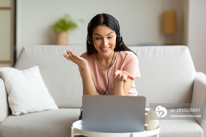 Woman In Headset Using Laptop Computer Making Video Call Indoors