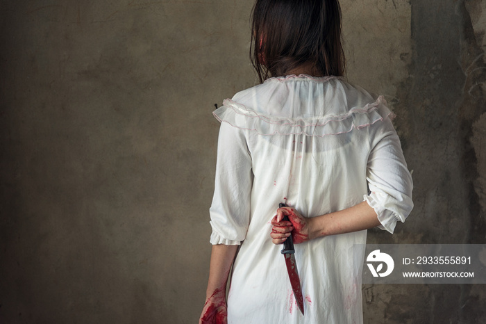 Woman holding knife back on her hand with blood