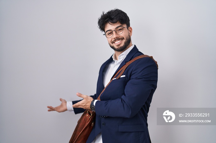 Hispanic man with beard wearing business clothes inviting to enter smiling natural with open hand