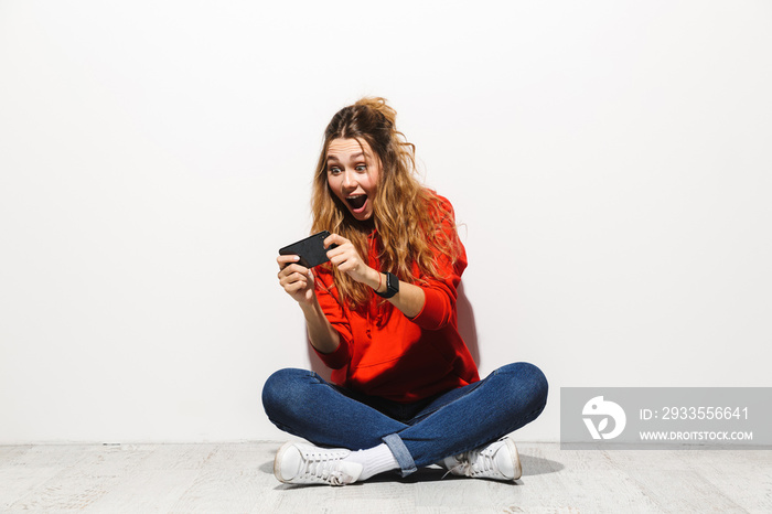 Portrait of an excited young woman wearing hoodie