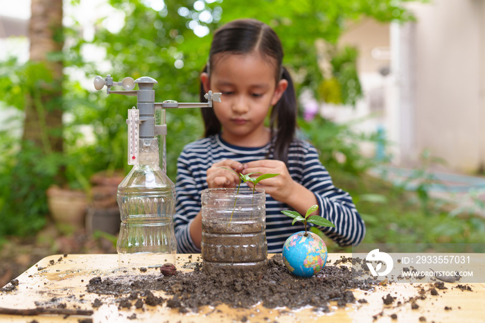 Blurred of little girl is learning science experiment at home and planting with recycle plastic bottle, concept of STEM, education, montessori, nature, environment, weather, climate change for kid.