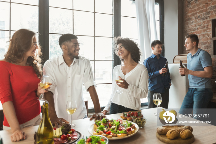 Group of happy people talking and eating at dinner party