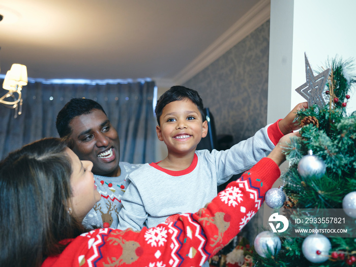 Parents and son decorating Christmas tree