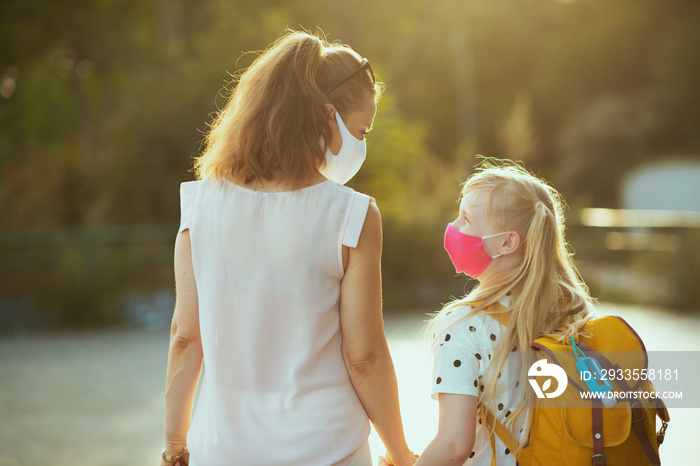 young mother and child coming back from school outside