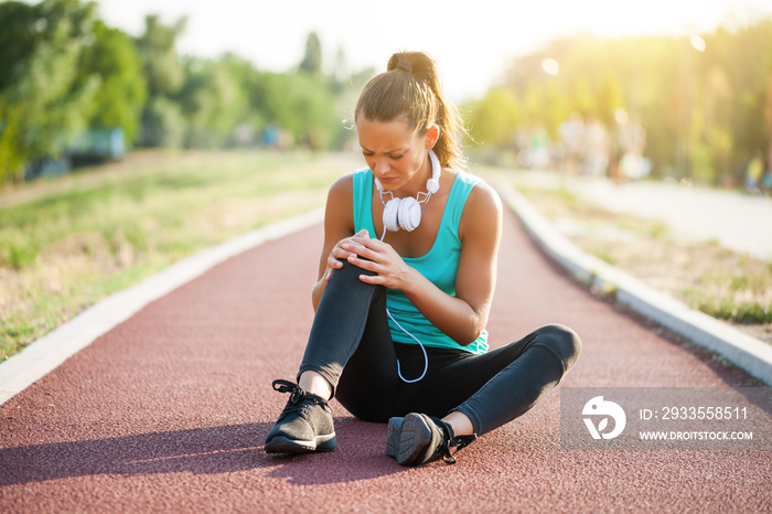 Young woman got injured while jogging on sunny day.