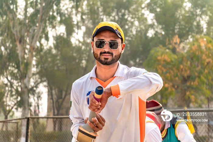 young cricketer holding a cricket bat on match ground