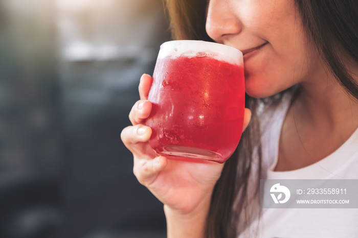 Closeup image of an asian woman enjoy drinking strawberry soda with feeling happy