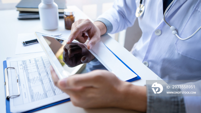 Doctor reading on a document report and writing on paperwork and searching treatment information at office, Medical healthcare concept.