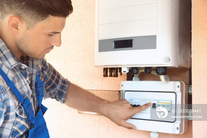 Worker connecting solar panels to control unit