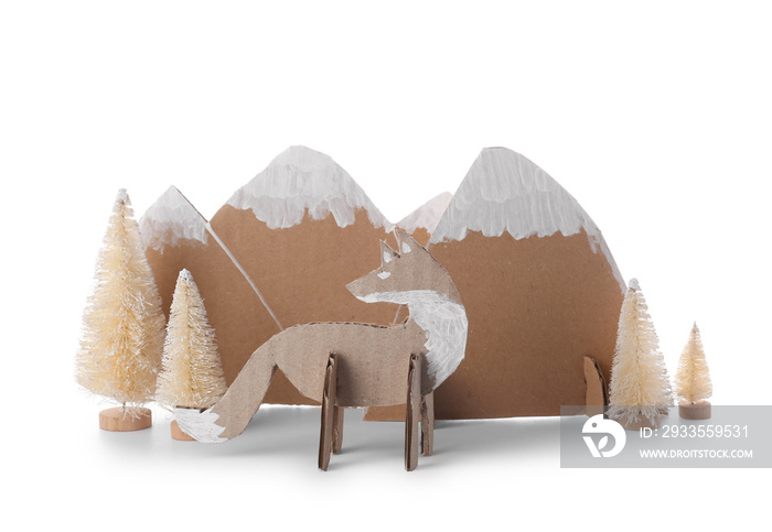 Handmade cardboard fox, mountains and fir trees on white background