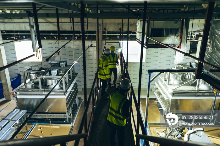 Mechanical engineer team working installation condensing unit system in machine room for cold storage room of factory.